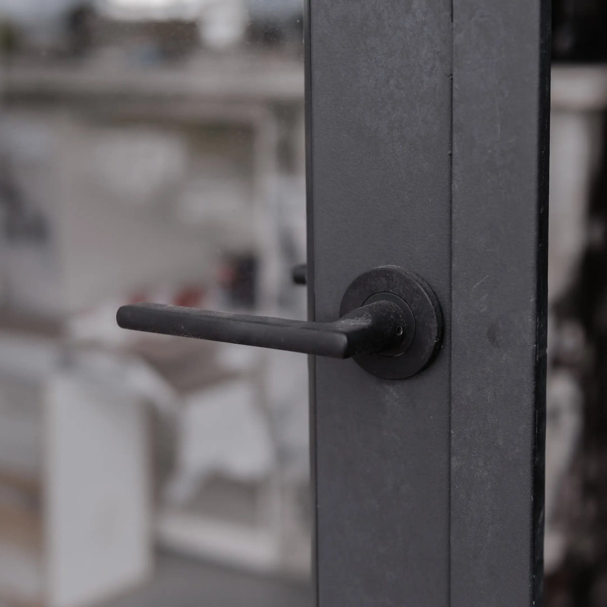 Forged lever handle on a steel door stile