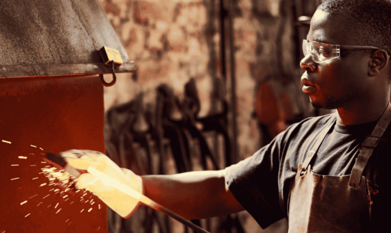 worker holding hot wrought iron metal piece