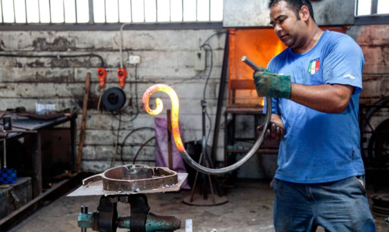 man shaping wrought iron piece
